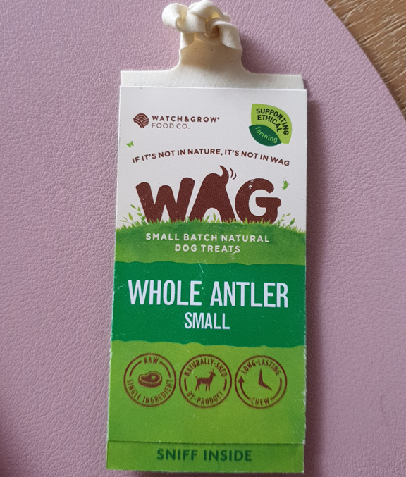 A package of WAG Small Whole Antler natural dog treats on a pink surface.