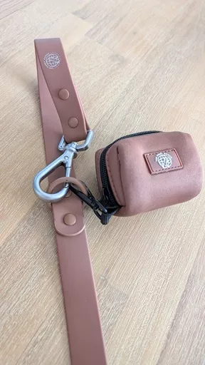he Furry Nomad Chocolate Brown waterproof multi-way leash with matching neoprene poop bag dispenser clipped onto the leash D-ring.