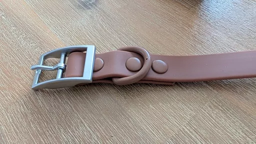 Close up of The Furry Nomad Chocolate Brown waterproof collar showing the silver metal pin buckle, D-ring, and colour-matched rivets.