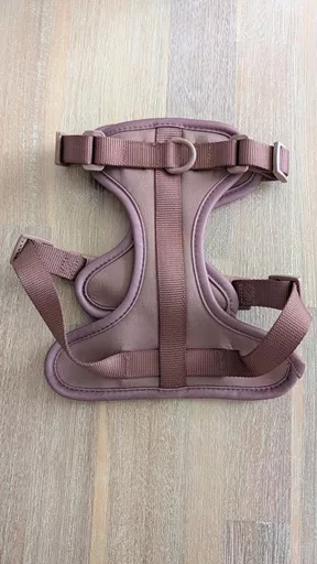 Flat lay product view of The Furry Nomad Chocolate Brown waterproof harness laid flat on a light wooden surface showing straps and chest D-ring.