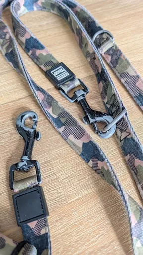 Close up of matte black metal swivel clips on the Stylish Hound multi-function leash showing silver wear at friction points after four years of daily use.
