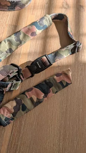 Flat lay detail of the Stylish Hound camo harness showing the side release plastic buckle and detached fabric anti-chafe sleeve.