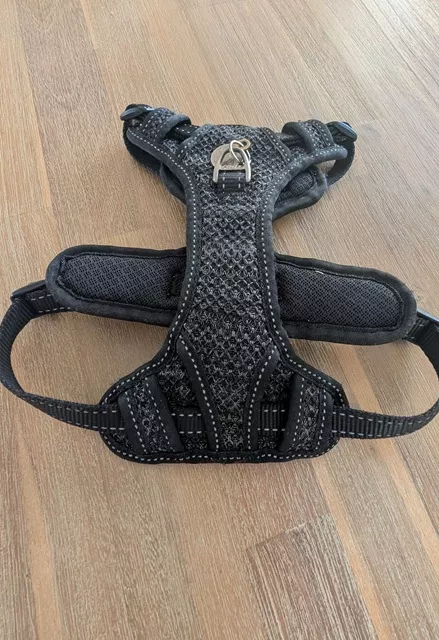 Black Rogz Utility Explore dog harness laid flat on a wooden surface, showing its durable mesh and stitching after three years of regular use.