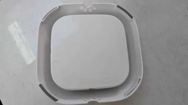 A bottom-up view of the All Fur You dog water bowl base, showing the layout of the anti-slip grey rubber feet on the corners.